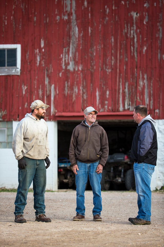 Farmers in front of farm building